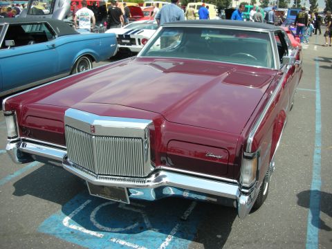 1992 Ford Crown Victoria - A maroon Lincoln Continental is parked in a handicapped spot at an outdoor car show.
