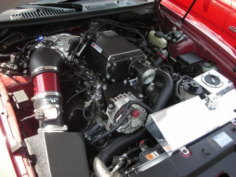 1992 Ford Crown Victoria - Close-up view of a modified V8 engine a prominent supercharger and custom intake system.
