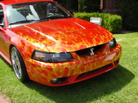 1992 Ford Crown Victoria - A red Ford Mustang with custom flame graphics is shown from the front-three-quarter view.