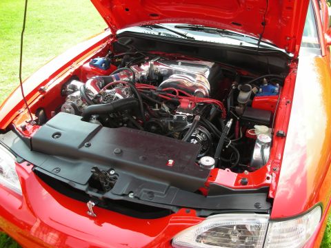 1992 Ford Crown Victoria - Engine bay of a red car, a supercharged V8 engine with chrome accents.