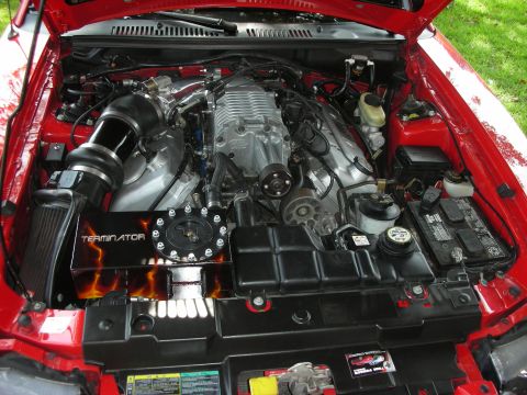 1992 Ford Crown Victoria - Close-up view of a modified engine bay a prominent supercharger and "TERMINATOR" branding on a custom cover.