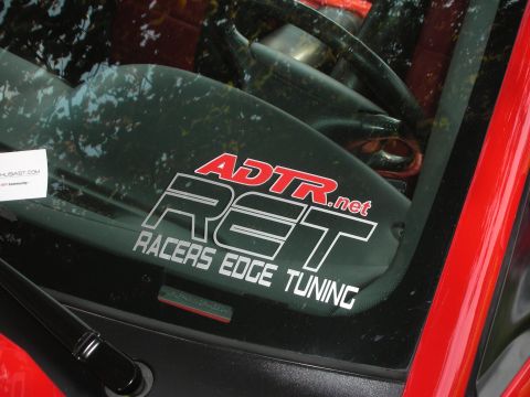 1992 Ford Crown Victoria - Stickers adorn the windshield of a car, with a glimpse of the interior and red trim visible.