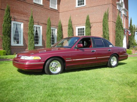 1992 Ford Crown Victoria - Maroon 1992 Ford Crown Victoria with chrome wheels sits on a lawn.