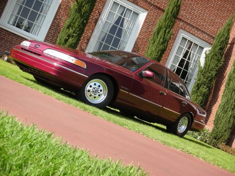 1992 Ford Crown Victoria - A maroon 1992 Ford Crown Victoria sedan is viewed from a low angle on a sunny day.
