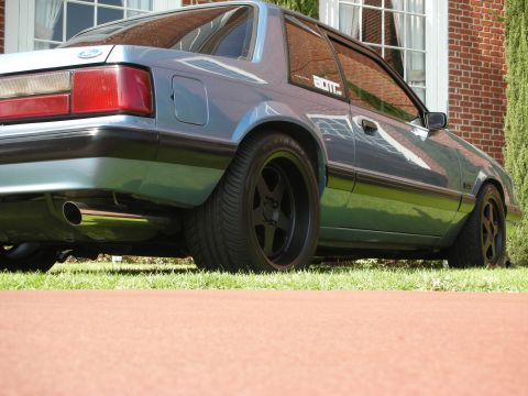 1992 Ford Crown Victoria - This blue coupe, seen from the rear, features black trim and wheels. The registry identifies it as a 1992 Ford Crown Victoria, though the b…