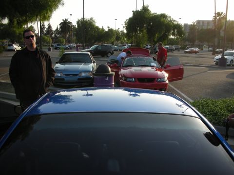 1992 Ford Crown Victoria - Several cars and people gathered in a parking lot during an event.