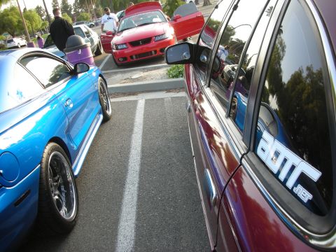 1992 Ford Crown Victoria - A red Ford Mustang is parked with its hood open, alongside a blue car in a parking lot.