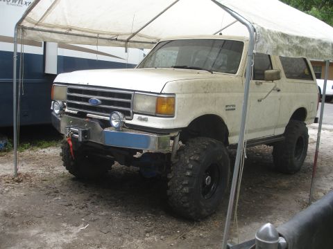 1989 Ford Bronco - This lifted 1989 Ford Bronco is parked under a canopy.