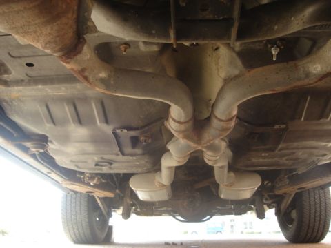 2000 Ford Crown Victoria - The underside of a vehicle is shown, focusing on the exhaust system and rear axle components.
