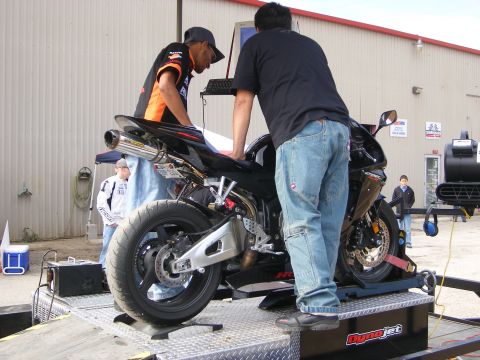 2006 Honda CBR-RR - A motorcycle is being prepared for testing on a dynamometer, with two individuals observing the process.