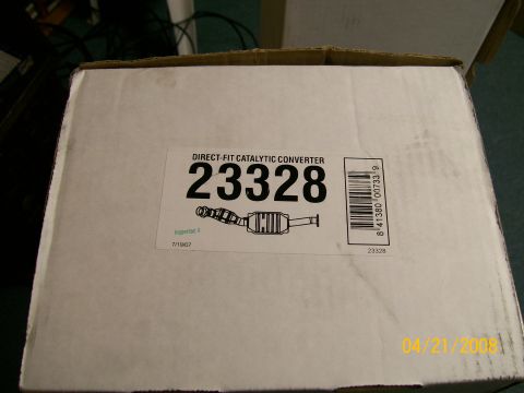 1995 Mercury Grand Marquis - A white cardboard parts box photographed from above, its label reading "DIRECT-FIT CATALYTIC CONVERTER" with part number 23328, a line draw…