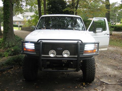 1996 Ford Bronco - Front view of a 1996 Ford Bronco parked outdoors with the driver's door ajar.
