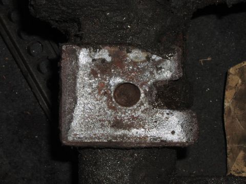 1986 Ford Bronco - Close-up of a rusted metal bracket on a shaft, likely a vehicle component.