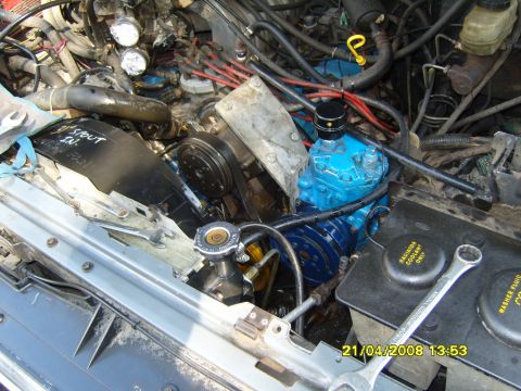 1989 Ford Bronco - Close-up of a vehicle's engine bay, focusing on the air conditioning compressor and related components.