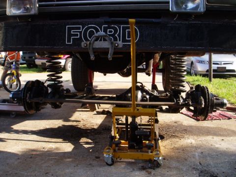 1980 Ford Bronco - The front axle and suspension of a Ford Bronco are being worked on, with a horseshoe mounted on the bumper.