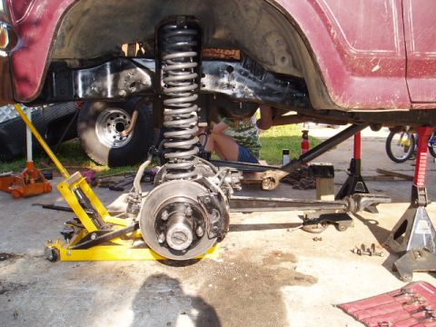 1980 Ford Bronco - Close-up view of a vehicle's undercarriage, showing suspension components and frame during maintenance.