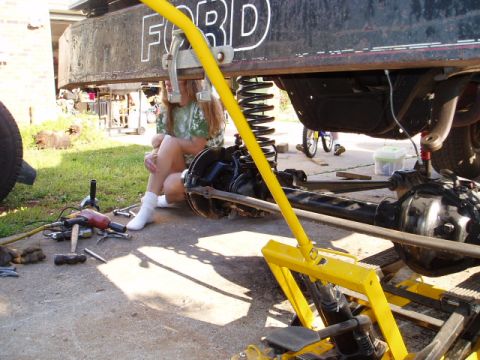 1980 Ford Bronco - Close-up view of the undercarriage of a Ford vehicle, showing suspension and axle work in progress.