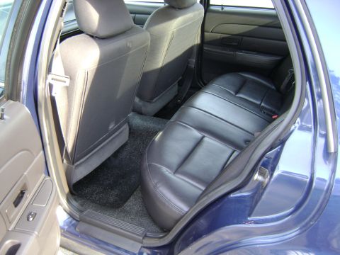2001 Ford Crown Victoria - The interior of a blue sedan shows black leather seats and dark carpeting.