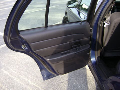 2001 Ford Crown Victoria - Interior view of a dark blue sedan's rear door, with another vehicle reflected in the side mirror.
