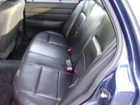 2001 Ford Crown Victoria - The interior of a blue vehicle, black leather rear seats and visible seatbelts.