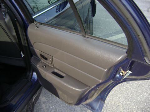 2001 Ford Crown Victoria - The interior door panel of a blue sedan is shown, with a view of the exterior through the window.
