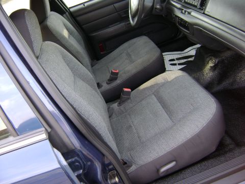 2001 Ford Crown Victoria - The interior of a car shows the front seats, dashboard, and door panel.