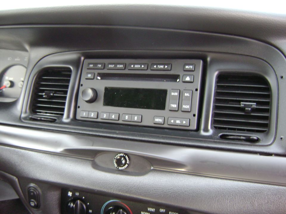 Car dashboard with radio, air vents, and climate controls