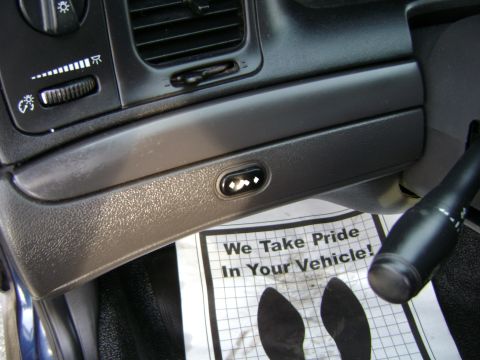 2001 Ford Crown Victoria - Close-up of the dashboard showing various controls and a floor mat with text.