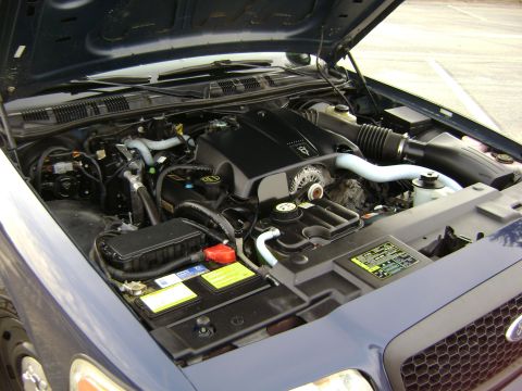 2001 Ford Crown Victoria - The engine bay of a blue 2001 Ford Crown Victoria is visible with the hood raised.