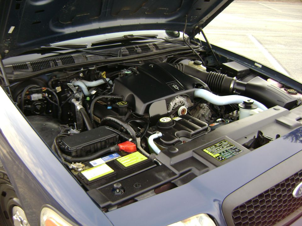 Blue 2001 Ford Crown Victoria engine bay with hood open, showing V8 engine, battery, and air intake