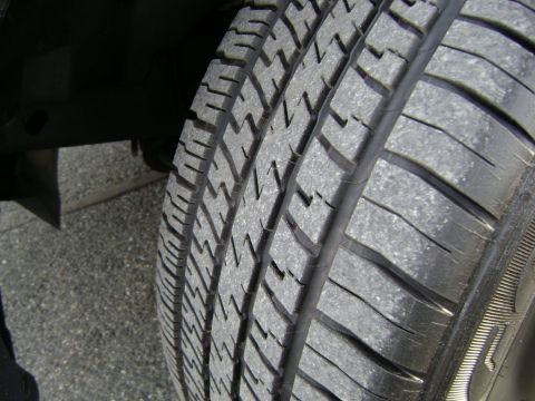 2001 Ford Crown Victoria - A close-up view of a tire's tread pattern on a paved surface.