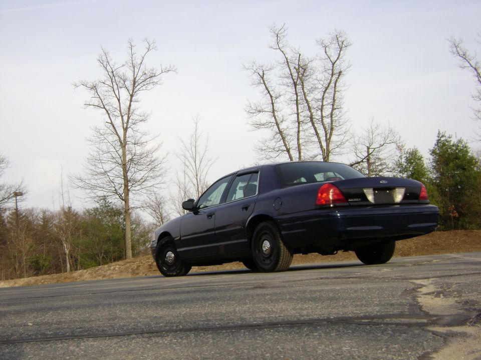 Dark blue 2001 Ford Crown Victoria, rear quarter view, parked on asphalt