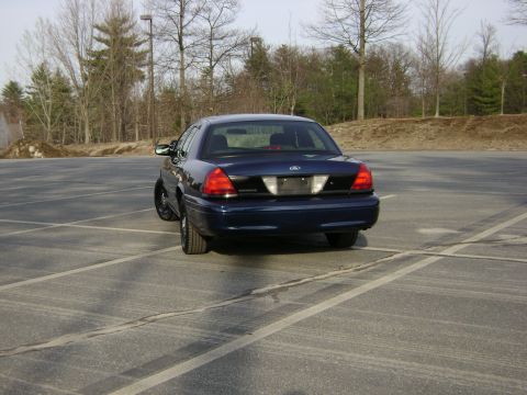 2001 Ford Crown Victoria - Rear view of a dark blue 2001 Ford Crown Victoria parked in an empty lot.