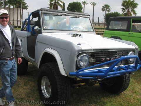 1968 Ford Mustang - A man stands next to a modified Ford Bronco, with another Bronco visible in the background.