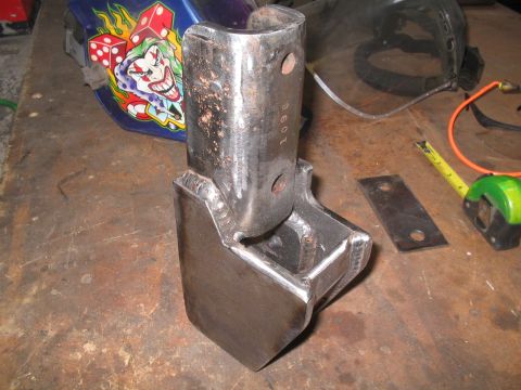 1979 Ford Bronco - A custom metal part, likely for automotive modification, sits on a workbench with tools.