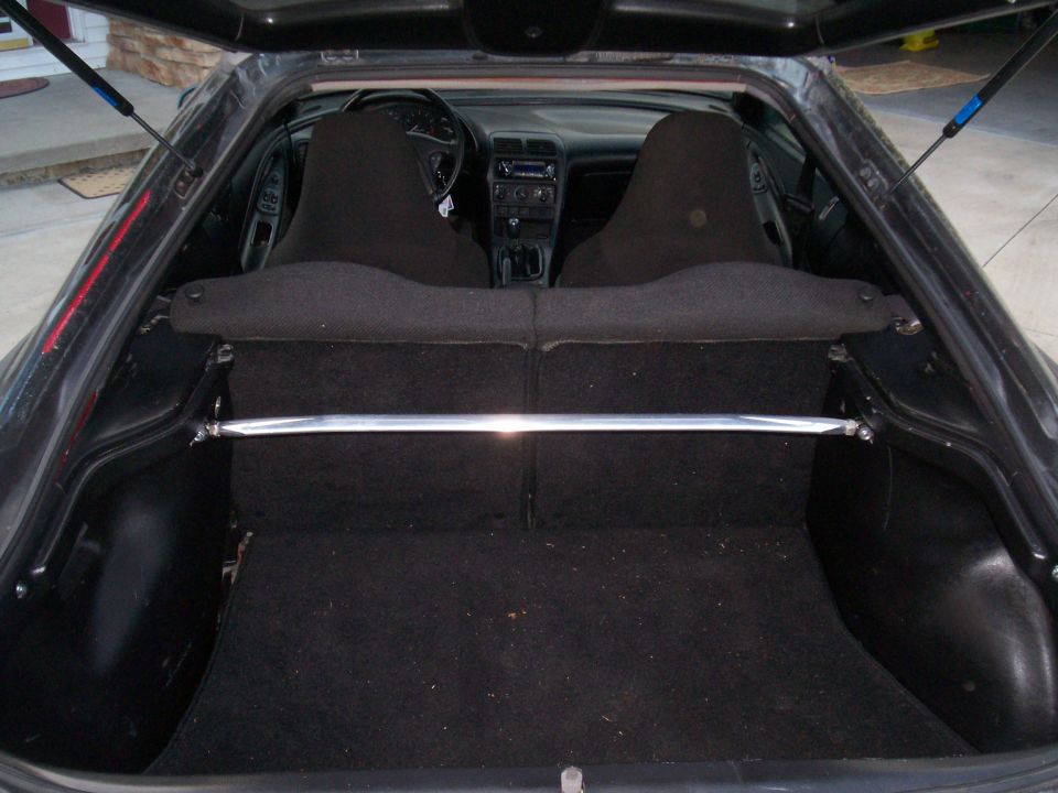 View of car's interior and open trunk with a strut bar