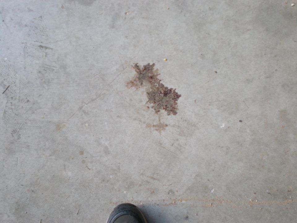 Oil stain on concrete floor with a shoe in the corner