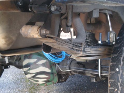 1993 Ford Bronco - Close-up of a vehicle's rear axle and suspension system with custom camouflage paint.