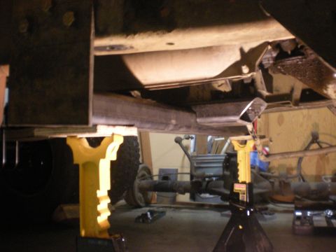 1993 Ford Bronco - The undercarriage of a 1993 Ford Bronco is visible, supported by jack stands, highlighting its suspension system.