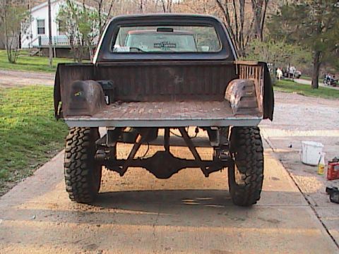 1980 Dodge Magnum - Rear view of a lifted pickup truck, possibly from the 1970s, with a visible interior of another vehicle.