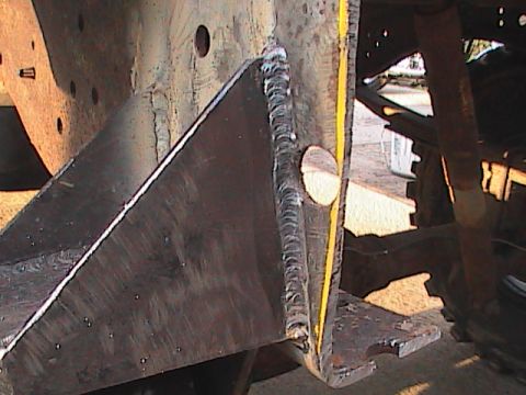 1980 Dodge Magnum - Close-up of a custom-welded metal bracket on a vehicle's chassis, with visible weld marks and a yellow painted stripe.