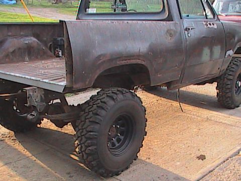 1980 Dodge Magnum - This lifted pickup truck appears to be a project vehicle, showing significant rust and modifications.