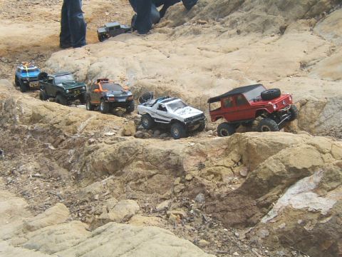 1988 Ford Bronco - A group of RC off-road vehicles are seen traversing a challenging rocky landscape.