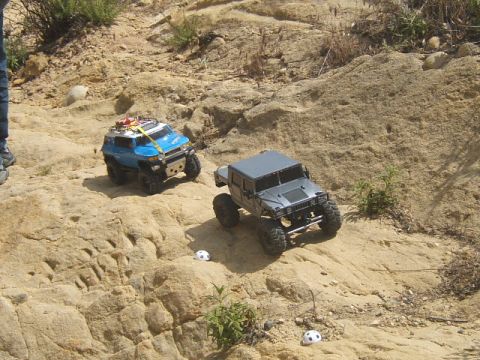 1988 Ford Bronco - Two remote control vehicles navigate a challenging rocky landscape.