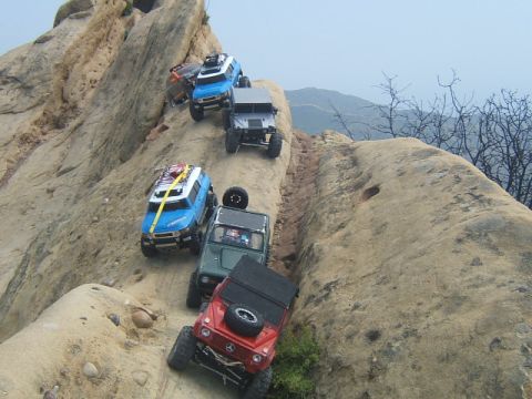 1988 Ford Bronco - RC vehicles navigate a challenging rocky terrain on a trail.