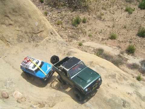 1988 Ford Bronco - Two toy vehicles navigate a rocky, outdoor terrain.
