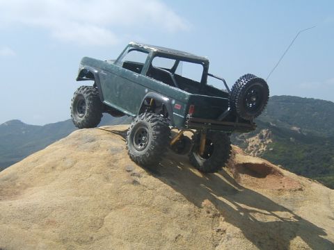 1988 Ford Bronco - This remote-controlled vehicle navigates a rocky incline under a clear blue sky.