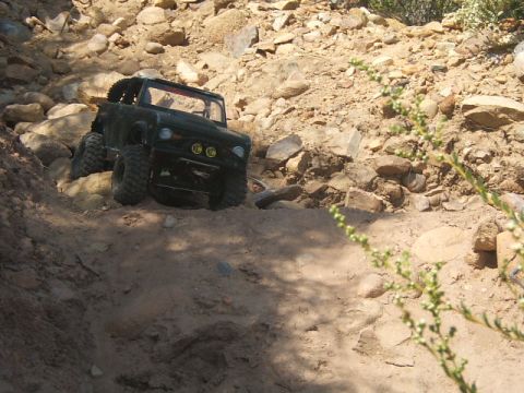 1988 Ford Bronco - A remote-controlled rock crawler navigates a rocky, off-road path.