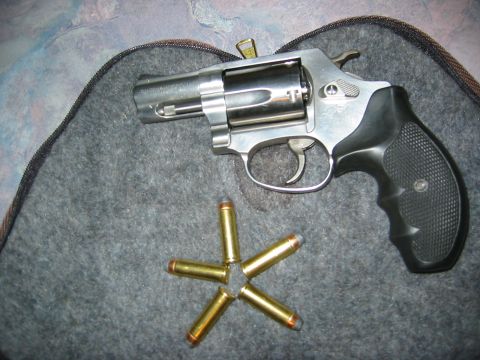 1996 Ford Bronco - A close-up view of a revolver and several cartridges laid out on a textured surface.