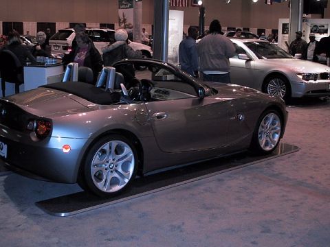 1996 Ford Taurus - A gray BMW Z4 convertible is displayed at an auto show, with other vehicles visible.